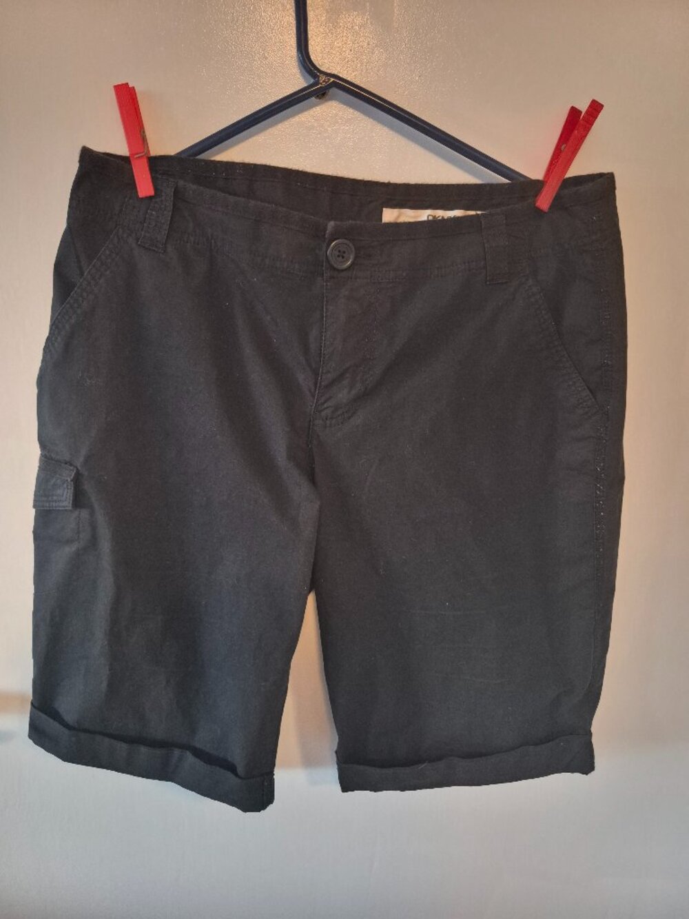 Black Bermuda shorts, cuffed hem and cargo pocket.